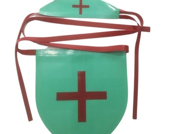 Könnte beinhalten: Ein grünes und rotes medizinisches Kostümzubehör mit einem roten Kreuz auf grünem Hintergrund. Das Zubehör hat zwei rote Bänder, die sich um die Taille binden.