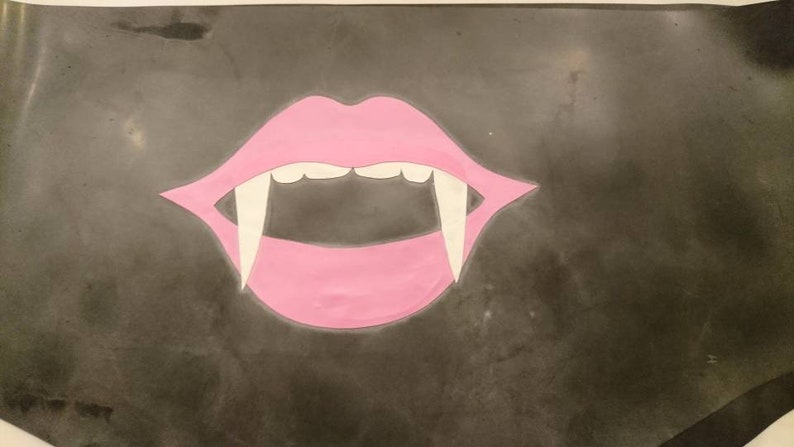 A pink mouth with white fangs on a dark gray background.