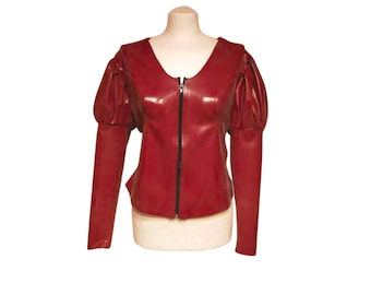 May include: A red jacket with a V-neckline and a black zipper closure. The jacket features long sleeves and puffed sleeves at the shoulders. The garment is displayed on a mannequin.