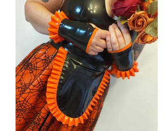 May include: Black latex dress with orange ruffled trim and a spiderweb pattern on the skirt. The dress has long sleeves with orange ruffled cuffs. A bouquet of roses is held in the hands.