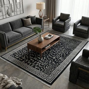 Könnte beinhalten: Moderne Wohnzimmereinrichtung mit einem grauen Sofa, zwei Sesseln und einem Couchtisch aus Holz. Ein schwarz-weiß gemusterter Teppich mit griechischem Schlüsselbordürenmuster liegt in der Mitte. Eine Lampe und Dekorationsartikel vervollständigen die Szene.