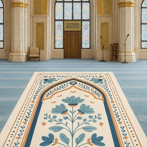 May include: An interior shot of a mosque featuring a prayer rug with a floral design in blue and orange. The rug is centered on a light blue carpet, with a large arched doorway and stained-glass windows in the background.