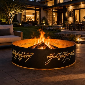 EN: Metal Black Speech fire pit ring inspired by the One Ring design glowing around a backyard fire | ES: Anillo para fogata inspirado en el One Ring brillando alrededor del fuego | FR: Anneau de foyer inspiré du One Ring illuminé autour du feu | DE: Feuerstellenring im One Ring Stil leuchtet am Lagerfeuer | IT: Anello per braciere ispirato al One Ring che illumina il fuoco