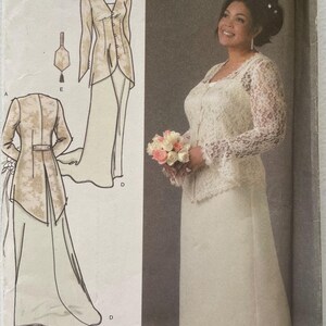 Puede incluir: Un sobre de patrón de costura Simplicity de la colección Khaliah Ali, talla FF 18W-24W. El frente muestra una chaqueta de encaje blanco y una falda larga, con dibujos técnicos que detallan la construcción de la prenda.