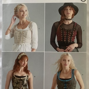 Peut inclure: Patron Simplicity Costumes avec quatre modèles de corsets. Le patron comprend les tailles 42-48. L'image présente différents styles de corsets, dont un de couleur crème avec des détails de laçage et un corset floral noir et or.