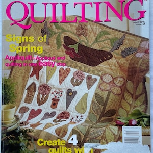 May include: The cover of American Patchwork & Quilting magazine, April 2002 issue. The cover features a quilt with floral and heart designs. Text includes "Signs of Spring" and "Create 4 quilts with 10 simple blocks."