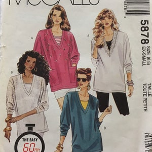 Può includere: Modello di cucito per tre top diversi, McCall's 5878, taglia 6-8, petite. Il modello include un maglione rosa con scollo a V e tasche, un maglione bianco con bordino in pizzo e un maglione blu-verde con scollo a V.