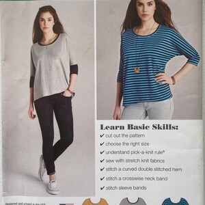 May include: Simplicity 1062 A Learn to Sew pattern envelope for sizes XXS-XXL. Features illustrations of three variations of a top with a curved hem and three-quarter sleeves: solid mustard, solid gray with dark cuffs, and blue and black stripes.