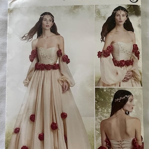 Peut inclure: Patron de costumes Simplicity R11852. Le patron présente une robe bustier avec des accents de roses rouges. La robe a un corsage ajusté et une jupe fluide. Le patron comprend les tailles 42-50.