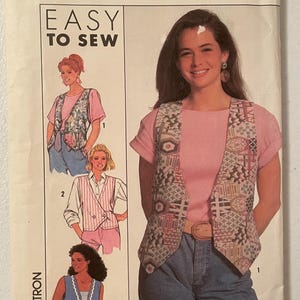 Peut inclure: Une pochette de patron de couture Simplicity portant le numéro 0649, taille A, Easy to Sew. Le devant présente des illustrations de trois styles de gilets différents, dont un gilet à motifs, un gilet croisé à rayures et un gilet uni à bordure festonnée.