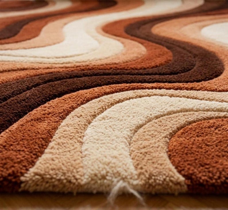 A close-up, low-angle view of the rug, showing the texture and wavy stripes in shades of brown, orange, and cream.
