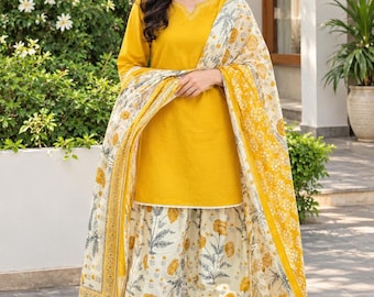 Könnte beinhalten: Eine senfgelbe Tunika mit gekerbtem Ausschnitt und weißer Stickerei, kombiniert mit einer weiten Hose und einem passenden Dupatta, die beide ein durchgehendes florales Muster in Weiß, Gelb und Grau aufweisen.