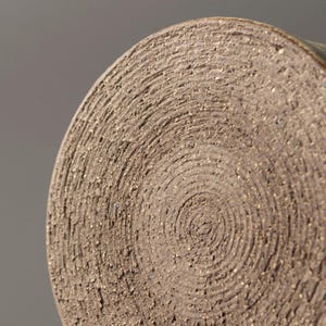 Close-up of the unglazed ceramic mug base showing natural clay rings and handmade marks
