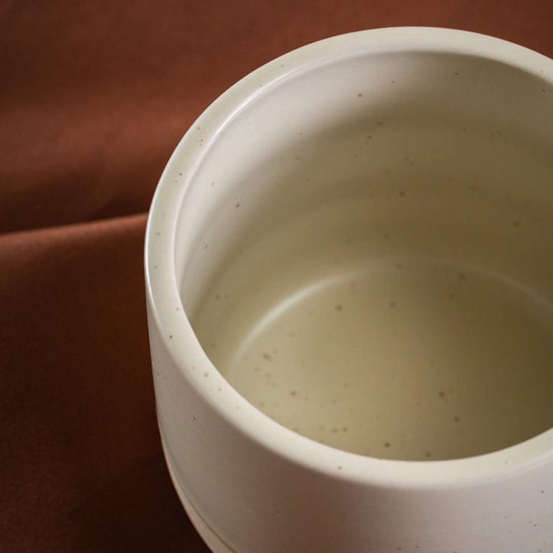 Interior close-up of handcrafted ceramic cup with smooth speckled glaze finish
