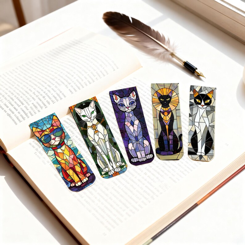 May include: Five colorful cat-themed bookmarks with stained glass designs rest on an open book. Each bookmark features a different cat design with vibrant colors and geometric patterns. A feather quill pen lies nearby.