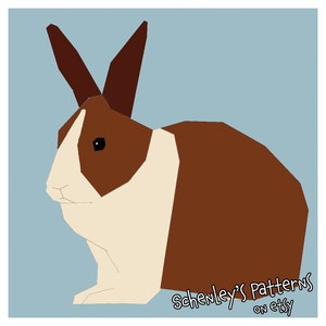 An illustration of this quilt pattern.  A rabbit is seen from the side.  It has dutch coloring, brown fur with a white band across its chest and a white stripe on its head.