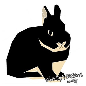 May include: A black and tan geometric illustration of a rabbit sitting with its ears perked up. The image includes the text "Schenley's Patterns on Etsy".