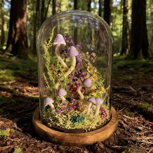 Pu&ograve; includere: Un terrario a campana di vetro con sculture di funghi lavanda in miniatura tra fiori secchi e muschio. Il terrario poggia su una base di legno rotonda, creando una scena boschiva stravagante. Lo sfondo &egrave; una foresta sfocata.