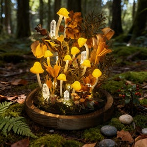 May include: A decorative arrangement featuring glowing yellow mushroom lights, clear crystal accents, and dried foliage, set within a wooden bowl. The scene is illuminated, creating a whimsical, fairy-tale aesthetic. The arrangement is surrounded by moss and forest elements.