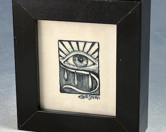 Framed ceramic tile with eye, black and white 4x4.2 inches