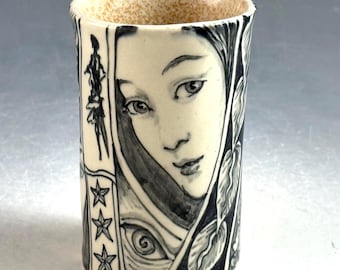 story cup in black and cream with rabbit, faces and more, 3.75 inches tall
