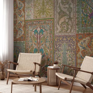 Puede incluir: Un salón con papel pintado estampado con diseños florales y geométricos en tonos naranja, verde, azul y morado. Dos sillas de madera con asientos tejidos y una mesa de centro redonda están frente a la pared. También se ve una pequeña mesa auxiliar y un jarrón.