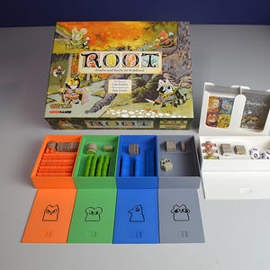 Könnte beinhalten: Die Root-Brettspielschachtel zeigt bunte Illustrationen von Waldtieren. Unter der Schachtel befinden sich vier rechteckige Kunststoffschalen in Orange, Grün, Blau und Grau, jeweils mit einem passenden Deckel, der ein einfaches Tiersymbol zeigt. Ein weißer Kartenhalter enthält Spielkarten und zwei weiße Würfel.