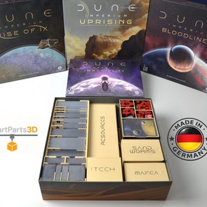 Puede incluir: Un organizador de juegos de mesa para el juego de mesa Dune: Imperium, con cajas y compartimentos para cartas y piezas de juego. El organizador está en una caja con las cajas del juego en el fondo. El organizador tiene el texto "RESOURCES", "ITCCH", "SAND WORMS" y "MAFEA".