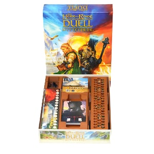 Könnte beinhalten: Geöffnete Brettspielbox mit dem Titel "Der Herr der Ringe Duell Mittelerde". Die Box-Art zeigt Figuren und eine Landschaft. Im Inneren enthält ein Holztablett Spielkomponenten, darunter Karten und Spielsteine.