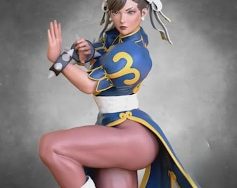 May include: A figurine of a woman in a blue and gold dress with a high slit, white boots, and a spiky wristband. Her hair is styled in two buns with white ribbons. The figurine is posed in a fighting stance.