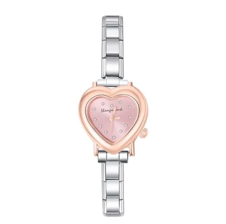 May include: A silver and rose gold wristwatch with a heart-shaped face. The watch face is pink with small, clear crystals and the words "Shanzin ink". The watch has a silver band.