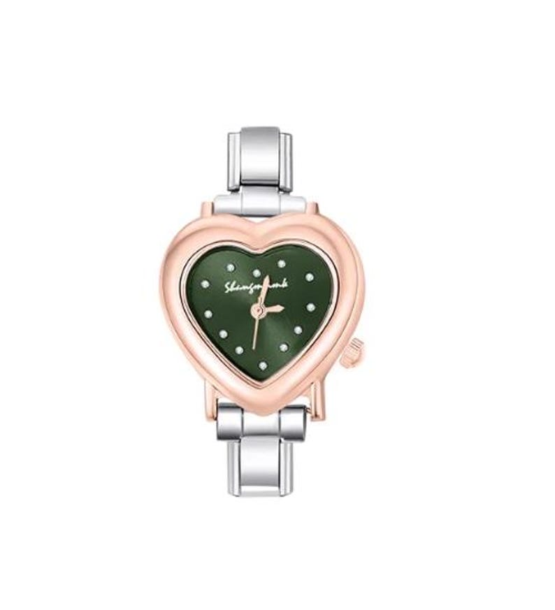 May include: A heart-shaped wristwatch with a rose gold bezel and a dark green face. The watch face has small, white dot hour markers and the text "Shamfomomb". The watch band is silver-toned metal.