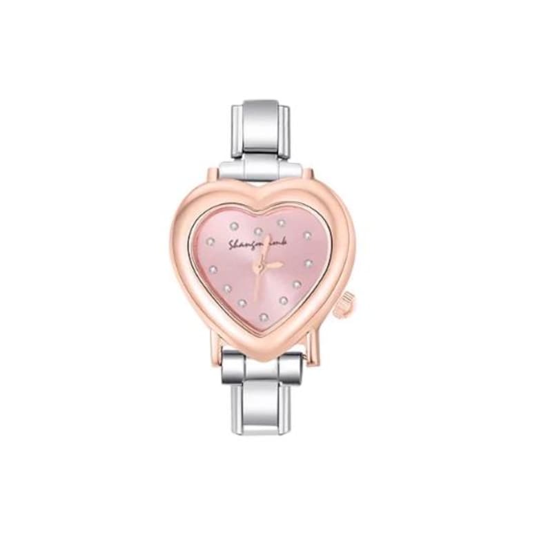 May include: A heart-shaped wristwatch with a pink face and silver band. The watch face has small, sparkling accents and the brand name "Shannon comb". The watch has a rose gold bezel and a silver band.