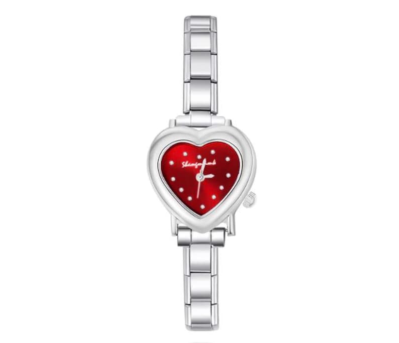 May include: A silver-toned wristwatch with a heart-shaped face. The watch face is red with white dots and the text "Shangfujia". The watch band is made of silver links.