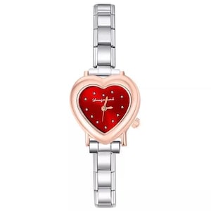 May include: A heart-shaped wristwatch with a red face and silver band. The watch face has small, sparkling accents and the text "Shining for love". The watch has a rose gold bezel and a silver link band.