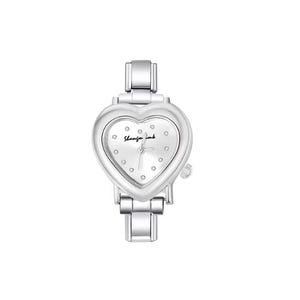 May include: A silver-toned wristwatch with a heart-shaped face. The watch face is white with small, round embellishments and the text "Shangfor ink". The watch has a metal band and a small dial on the side.