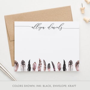 May include: Personalised stationery with the name "alison daniels" in cursive script. The stationery features a border of black and pink feathers at the bottom.
