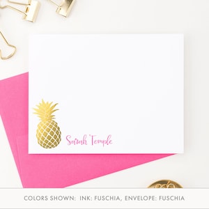 May include: A white card with a gold pineapple illustration and the text "Sarah Temple" in pink. The card is on a pink envelope. The text "COLORS SHOWN: INK: FUCHSIA, ENVELOPE: FUCHSIA" is below the card.