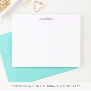 May include: A white stationery card with a pink line and the name "penelope" printed in pink. The card is shown with a light blue envelope.
