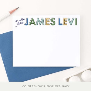 K&ouml;nnte beinhalten: Eine wei&szlig;e Karte mit einem marineblauen Umschlag. Die Karte tr&auml;gt den Text "a note from" und den Namen "JAMES LEVI" in bunten Blockbuchstaben.