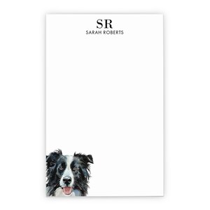 May include: White notepad with a watercolor illustration of a Border Collie dog at the bottom. The top of the notepad has the initials "SR" above the name "SARAH ROBERTS" in black text.