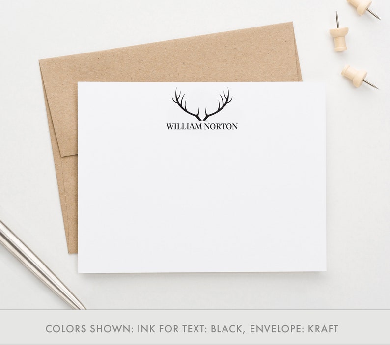 May include: A white stationery card with a black antler design and the name "William Norton" printed in black text. The card is on a brown kraft envelope.