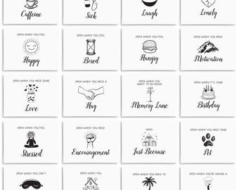 May include: A set of 16 small cards with black and white illustrations and text. Each card has a different message and image, such as "Open when you need caffeine", "Open when you feel sick", "Open when you need to laugh", and "Open when you feel lonely".