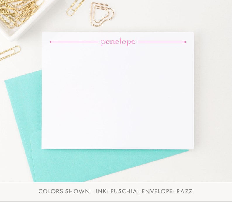 May include: A white stationery card with a pink line and the name "penelope" printed in pink. The card is shown with a light blue envelope.