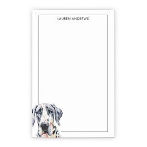 May include: A rectangular notepad featuring a white background with a thin black border. The name LAUREN ANDREWS is printed in black at the top center. A watercolor illustration of a black and white spotted Great Dane dog is at the bottom.