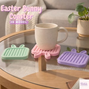 May include: Three Easter bunny-shaped coasters in pastel colors: mint green, pink, and lavender. A beige mug sits on the pink coaster. The coasters have a rectangular shape with bunny ear details. The text "Easter Bunny Coaster" is visible.