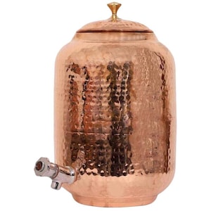 Puede incluir: Un dispensador de agua de cobre con textura martillada. El dispensador tiene un grifo y una tapa con un pomo decorativo. El acabado de cobre le da un aspecto rústico y elegante. Una adición elegante a cualquier cocina o comedor.