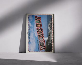 Könnte beinhalten: Ein rechteckiges Poster mit einer Küstenlandschaft, einem Leuchtturm, blauem Himmel und felsigem Gelände. Der Text lautet Greetings from WIDOWS BAY, The next Martha's Vineyard!, und enthält die Namen Matthew Rhys, Stephen Root und Kate O'Flynn.