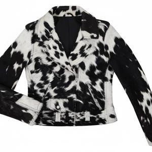 May include: A black and white cow print motorcycle jacket featuring a notched collar, silver-tone metal zippers on the front and cuffs, a small flap pocket, and an adjustable waist belt with a silver buckle, all in a textured finish.