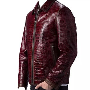 Puede incluir: Chaqueta de cuero burdeos con textura de piel de cocodrilo. La chaqueta tiene cierre de cremallera, cuello y ribete marr&oacute;n en los pu&ntilde;os y el cuello. Corte entallado y dise&ntilde;o cl&aacute;sico.